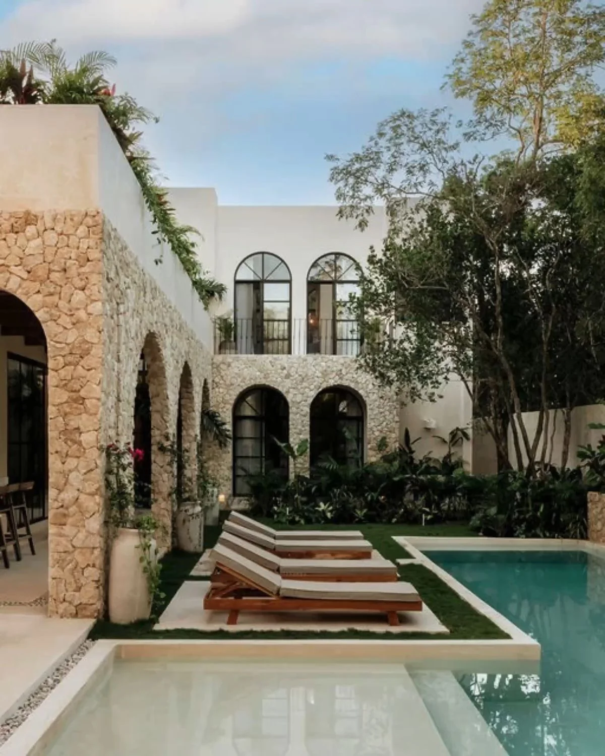 Villa de piedra natural con alberca en un entorno tropical